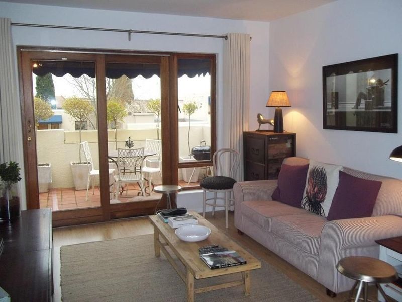 A cozy living room featuring laminate flooring and a large sliding glass door that provides direct access to an outdoor patio area.