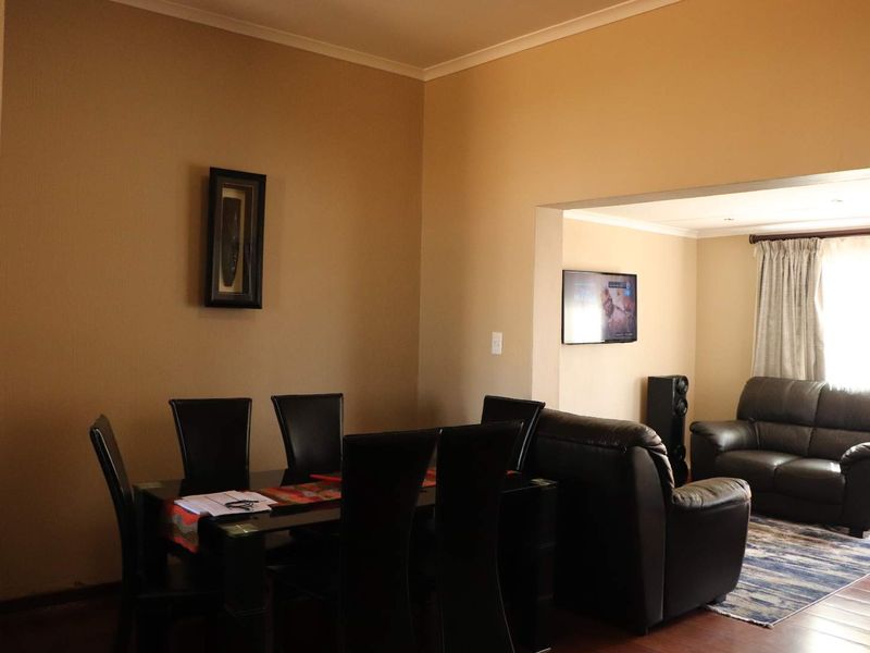 Open-plan living and dining area featuring laminate flooring and neutral wall tones, providing a functional space for daily living and entertaining.