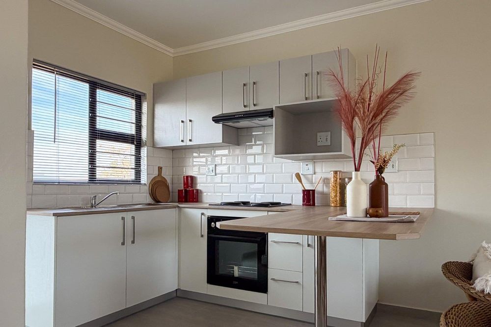 Kitchen with built-in cupboards + oven and sit-down countertop.