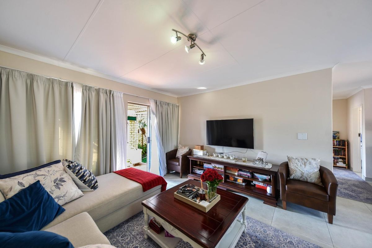 A bright living room featuring tiled flooring and a sliding glass door providing direct access to the outdoor patio area.
