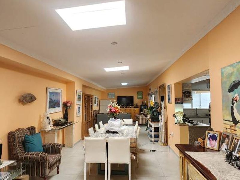 Spacious open-plan living and dining area featuring tiled flooring, multiple skylights, and recessed lighting, providing a bright and functional layout.