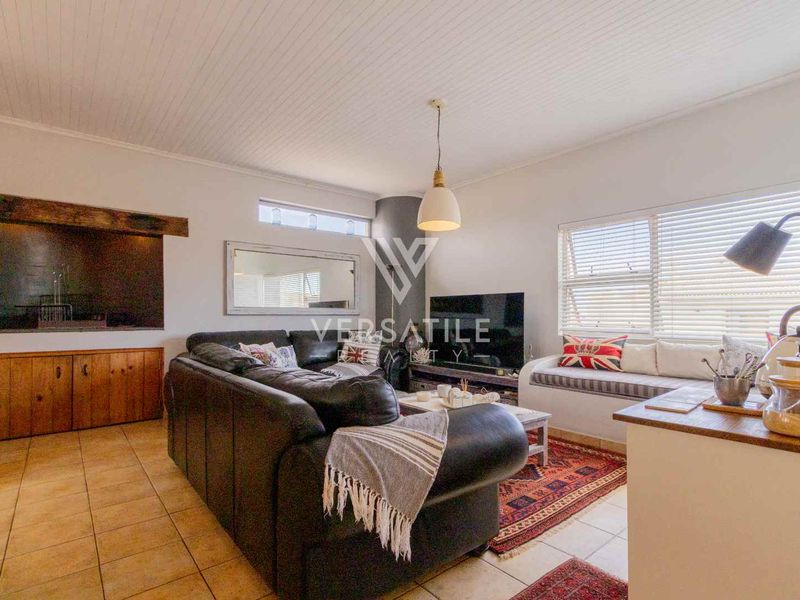 A comfortable living room featuring tiled flooring, a beadboard ceiling, built-in cabinetry, and a fireplace, creating a warm and inviting atmosphere.