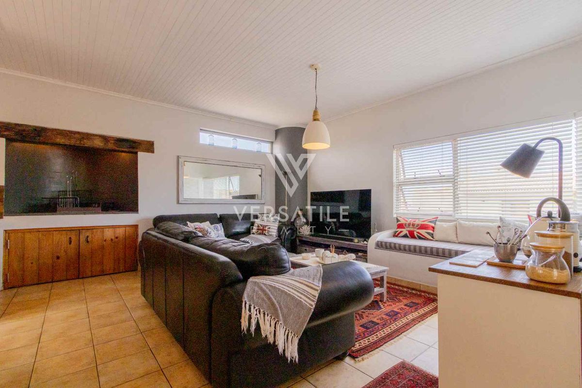 A comfortable living room featuring tiled flooring, a beadboard ceiling, built-in cabinetry, and a fireplace, creating a warm and inviting atmosphere.