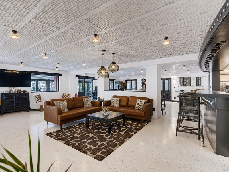Spacious open-plan retail or hospitality area featuring a textured ceiling, polished epoxy flooring, and a built-in bar counter with integrated lighting.