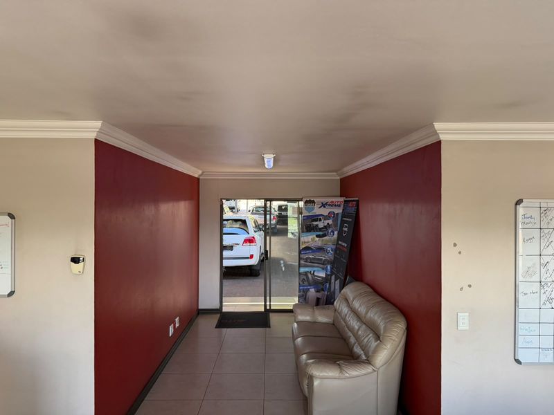 Entrance area featuring tiled flooring, sliding glass door access, and decorative cove cornicing, providing a functional transition space for the retail property.