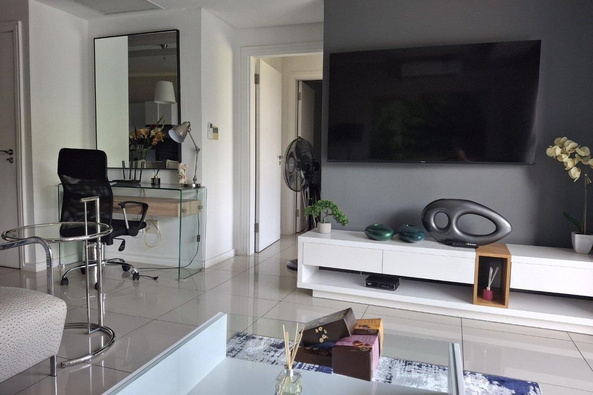 A modern living room featuring polished tiled flooring, a dark grey accent wall, and recessed ceiling lighting.