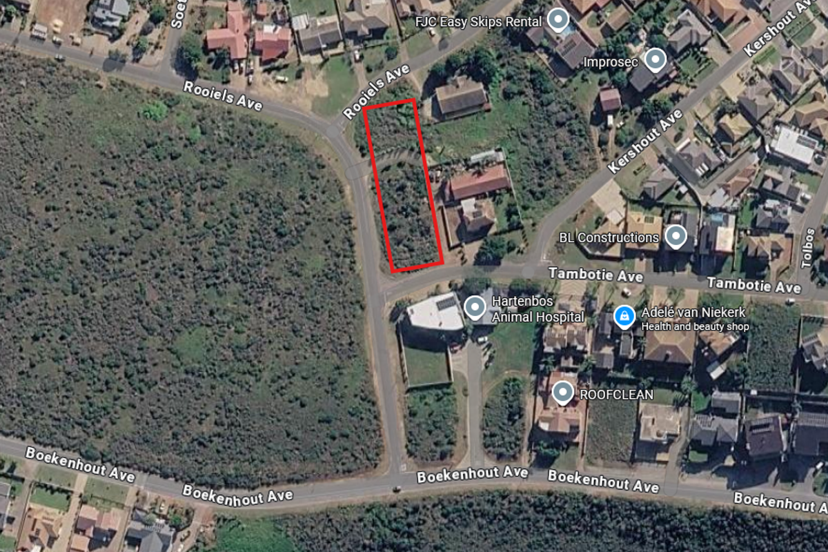 Aerial view of a vacant residential plot outlined in red, situated in a developed suburban neighborhood.