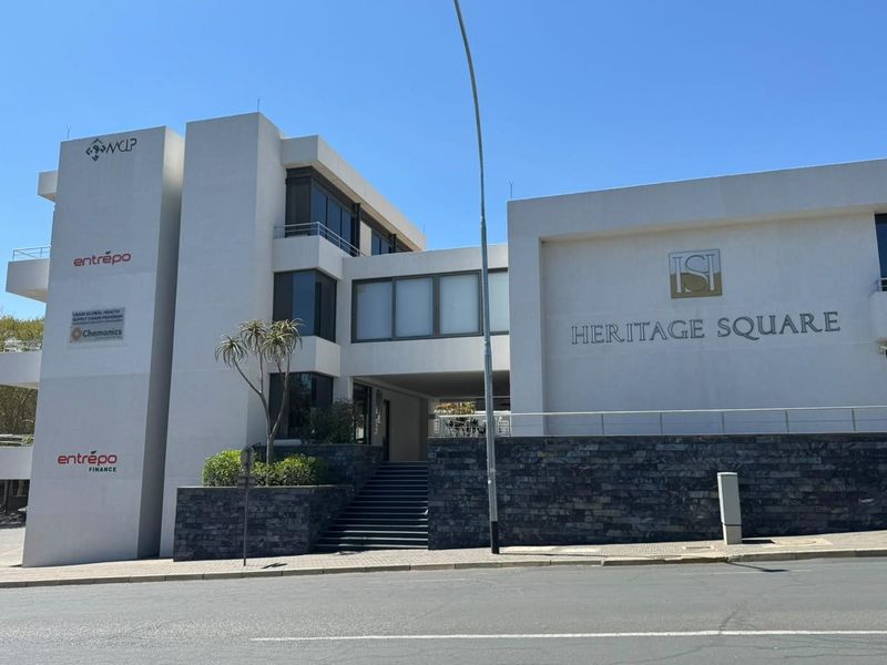 Front elevation of Heritage Square office building featuring modern white facade, stone cladding, and prominent corporate signage.