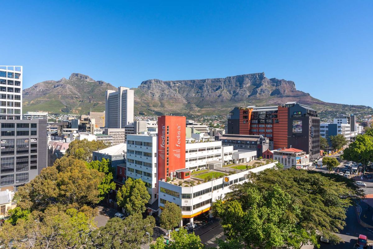 An elevated aerial view showcasing the urban cityscape with Table Mountain in the background.