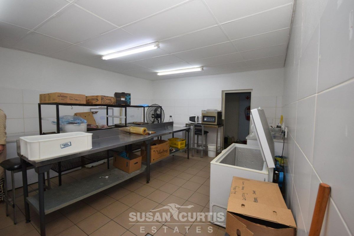 Functional commercial kitchen prep area featuring stainless steel work surfaces, tiled walls, and industrial lighting.