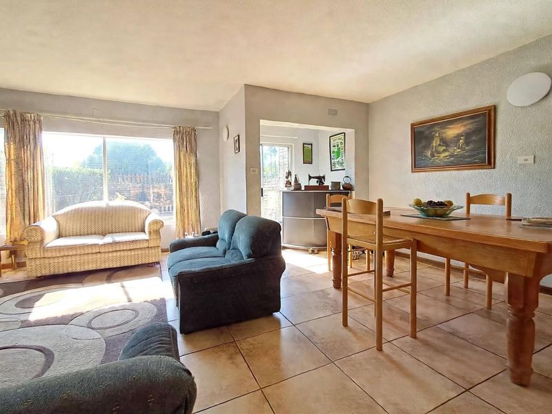 Open plan living and dining area featuring tiled flooring and a large sliding glass door providing natural light and access to the exterior.