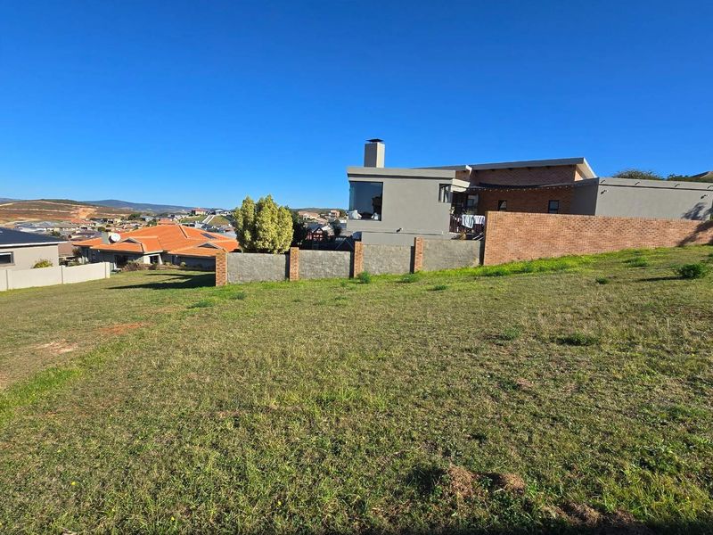A view of a vacant residential plot featuring established boundary walls and surrounding neighborhood infrastructure.