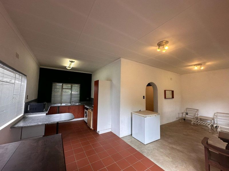 Open plan kitchen and living area featuring tiled flooring, built-in cabinetry, and a distinctive archway leading to adjacent spaces.