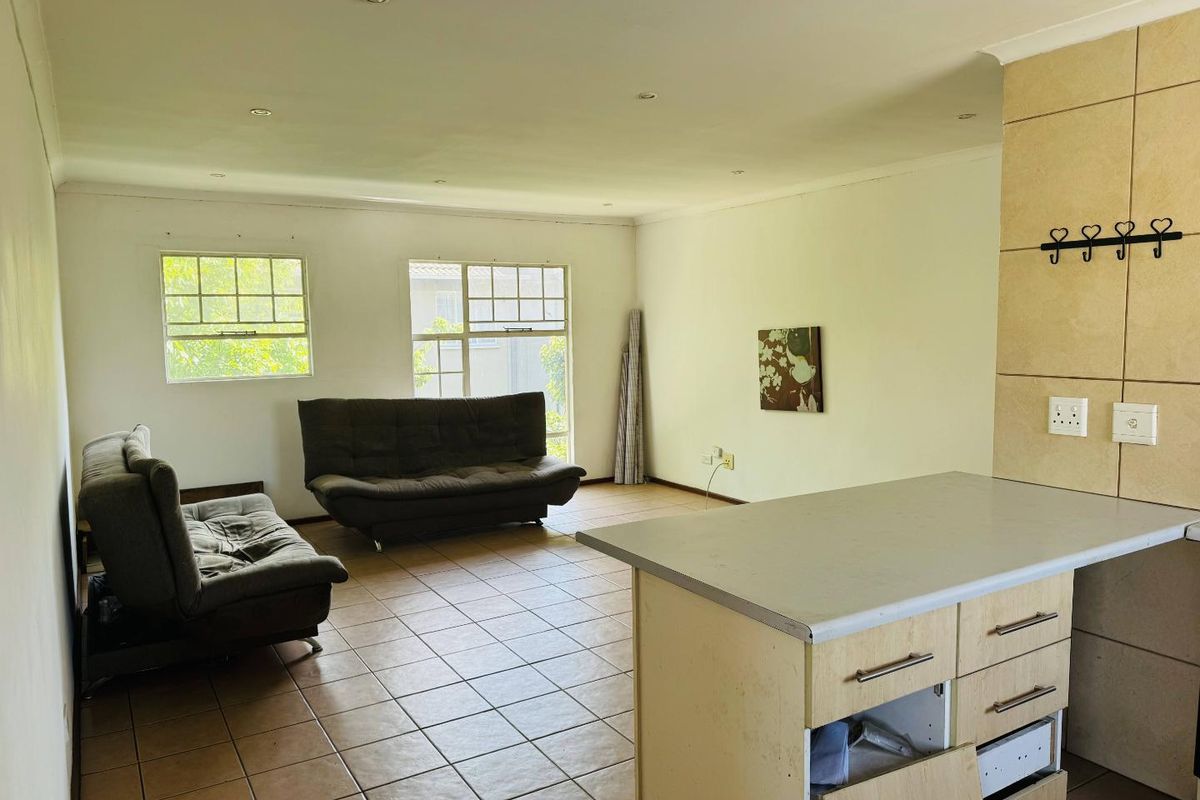 Open plan living area featuring tiled flooring, recessed lighting, and a kitchen island with built-in cabinetry and laminate countertops.
