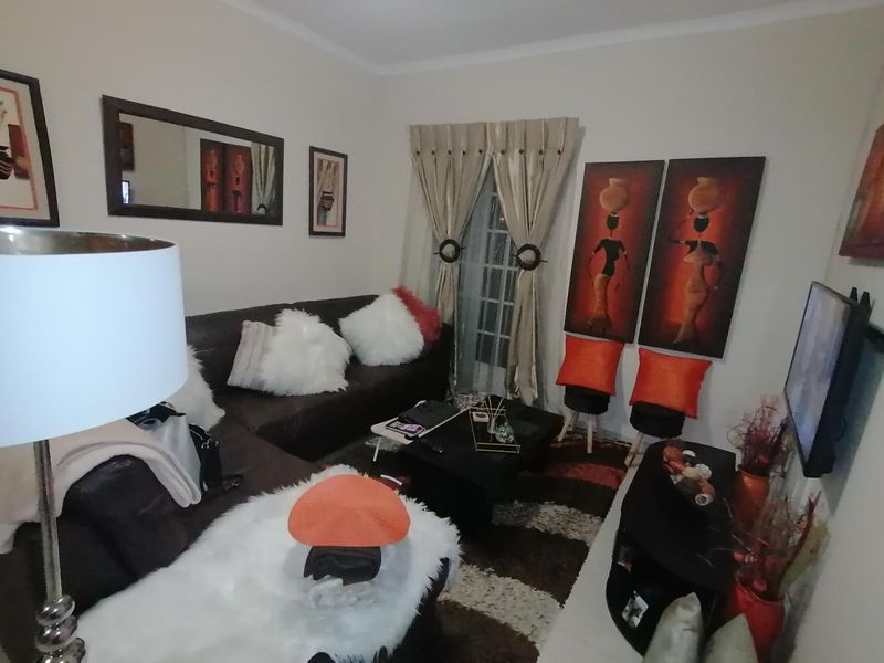 A compact living room featuring a sliding glass door with curtains and neutral wall finishes.