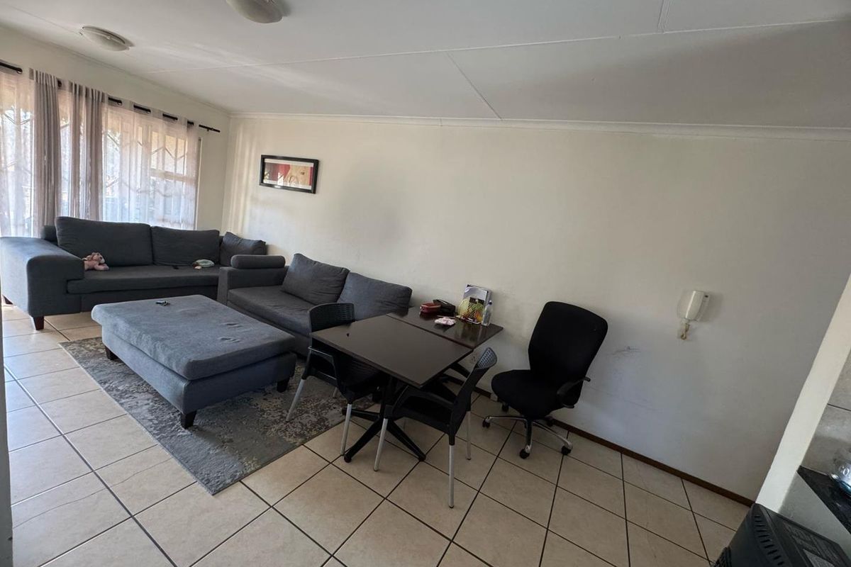 A spacious living area featuring neutral tiled flooring and an intercom system, offering a functional layout for comfortable daily living.
