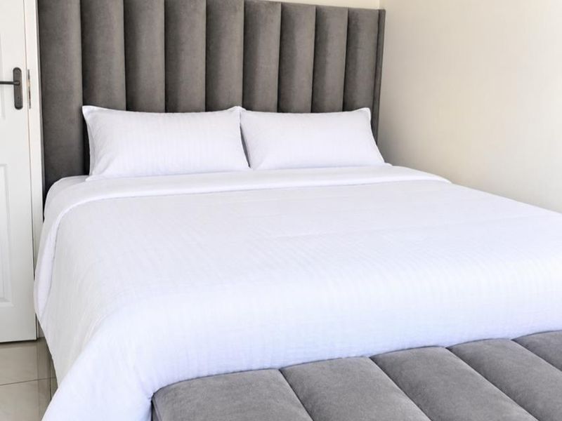 A well-maintained bedroom featuring neutral wall finishes and tiled flooring, providing a clean and comfortable living space.