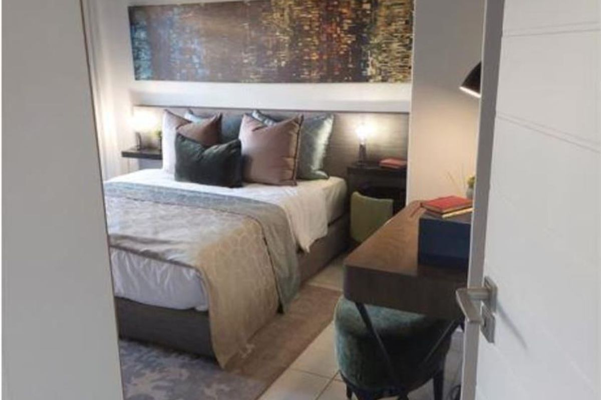 A well-maintained bedroom featuring tiled flooring, neutral wall tones, and a built-in headboard design, viewed through a doorway.