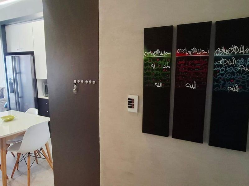 An open-plan living and dining area featuring modern kitchen cabinetry and neutral tiled flooring, creating a functional and connected living space.