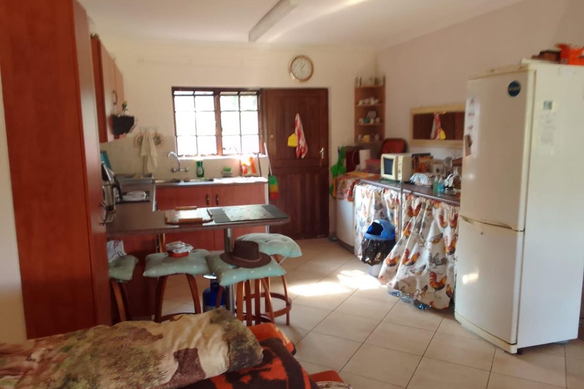 A functional kitchen area featuring tiled flooring, a breakfast nook, and basic cabinetry, offering potential for modernization and layout optimization.