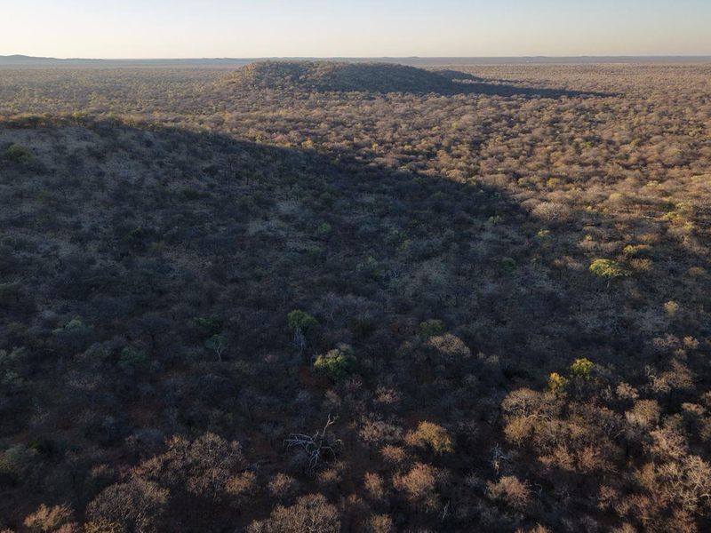 An expansive aerial view of the surrounding natural bushveld landscape, showcasing the vast, untouched terrain typical of the lodge's location.