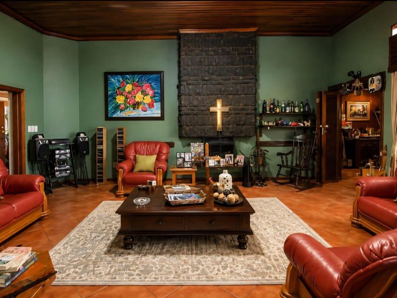 Spacious living room featuring a prominent brick fireplace, warm timber ceiling, and traditional terracotta floor tiles.