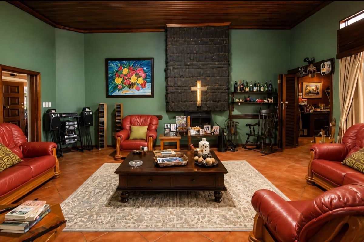 Spacious living room featuring a prominent brick fireplace, warm timber ceiling, and traditional terracotta floor tiles.