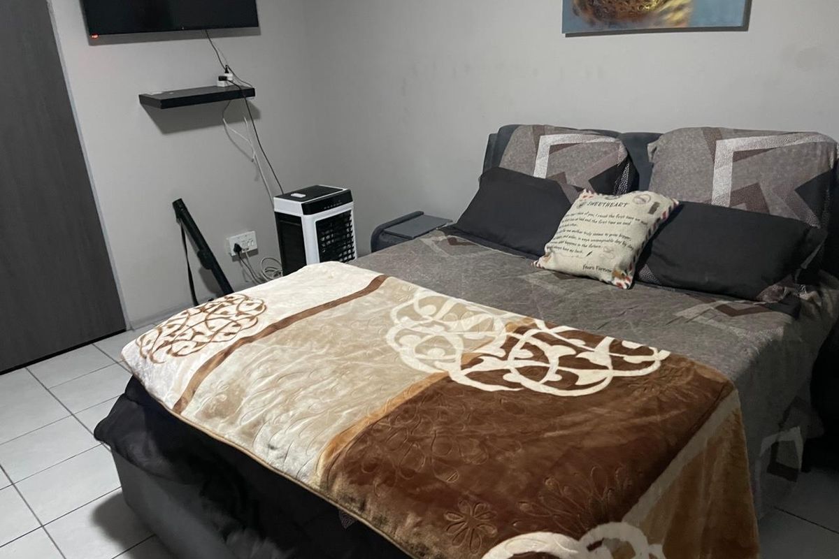 A bedroom featuring tiled flooring and neutral wall finishes, providing a functional and straightforward living space.