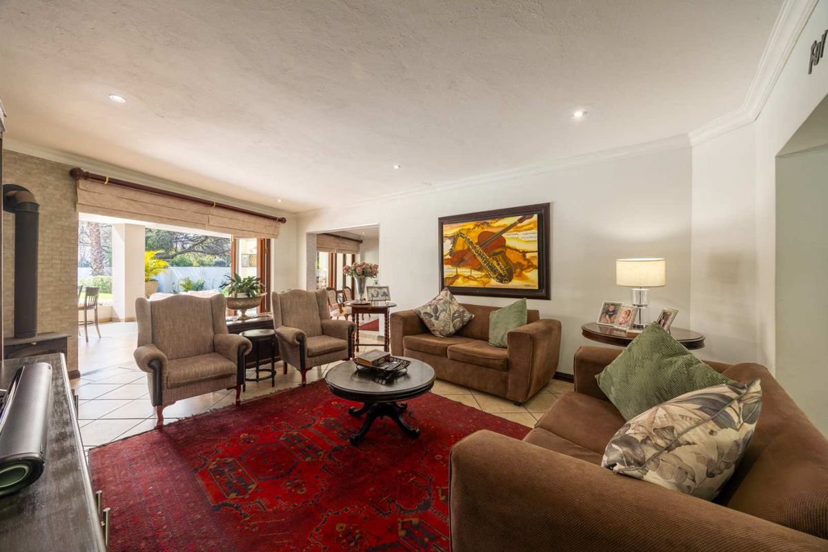 Spacious living room featuring tiled flooring, recessed lighting, and a wood-burning fireplace, with seamless access to an outdoor patio area.