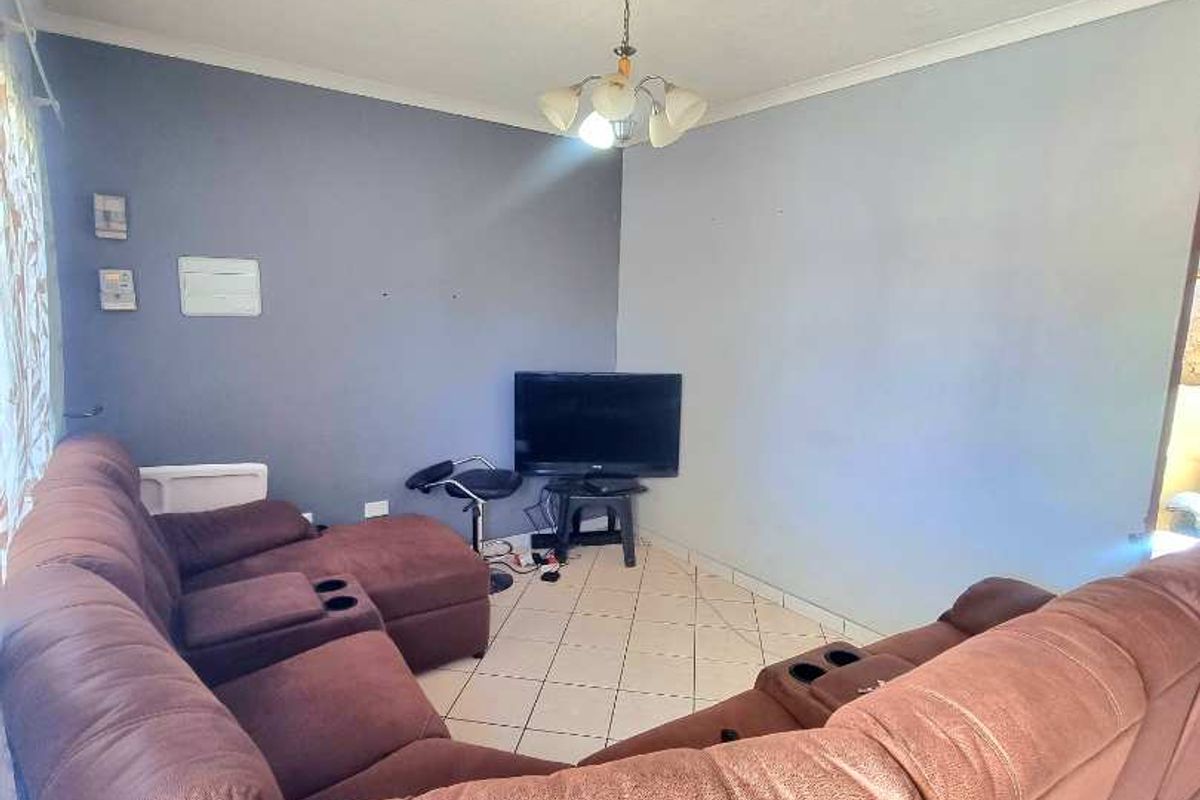 A living room featuring tiled flooring and a central ceiling light fixture, providing a functional space for relaxation.