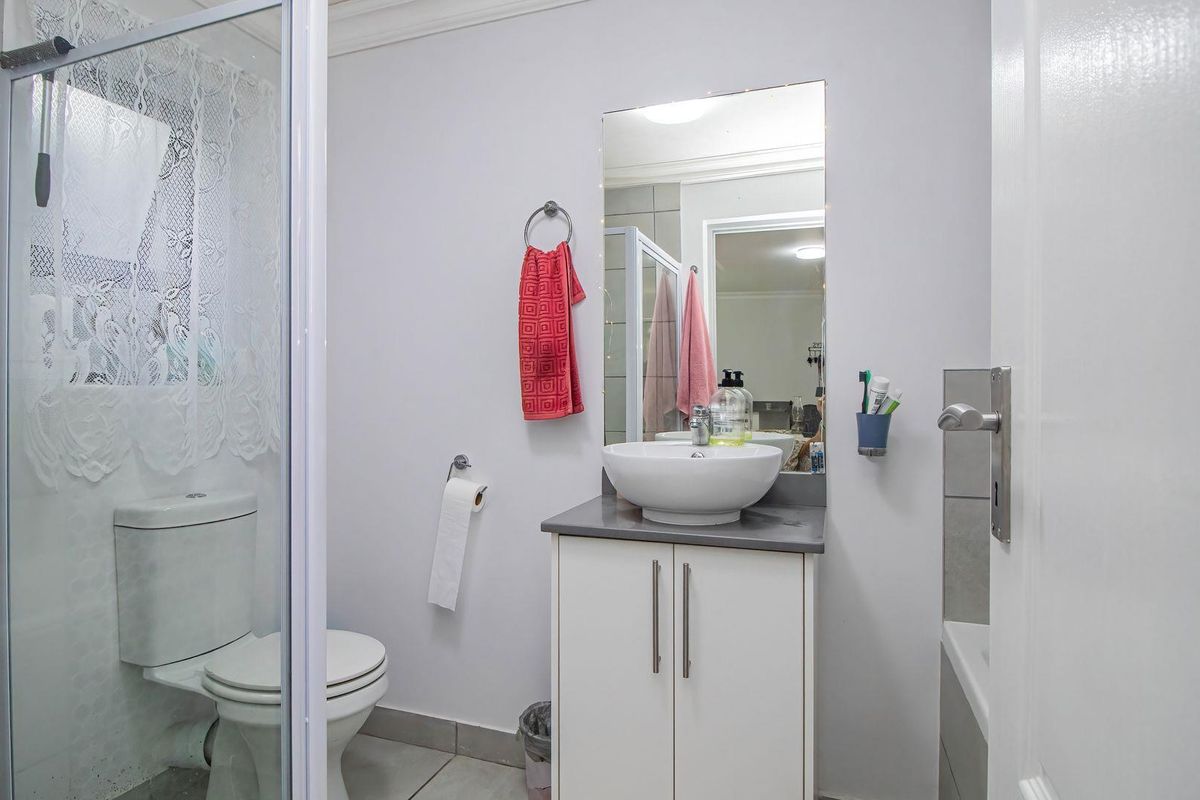 A functional bathroom featuring a shower enclosure, a modern vessel sink vanity, and neutral wall finishes.