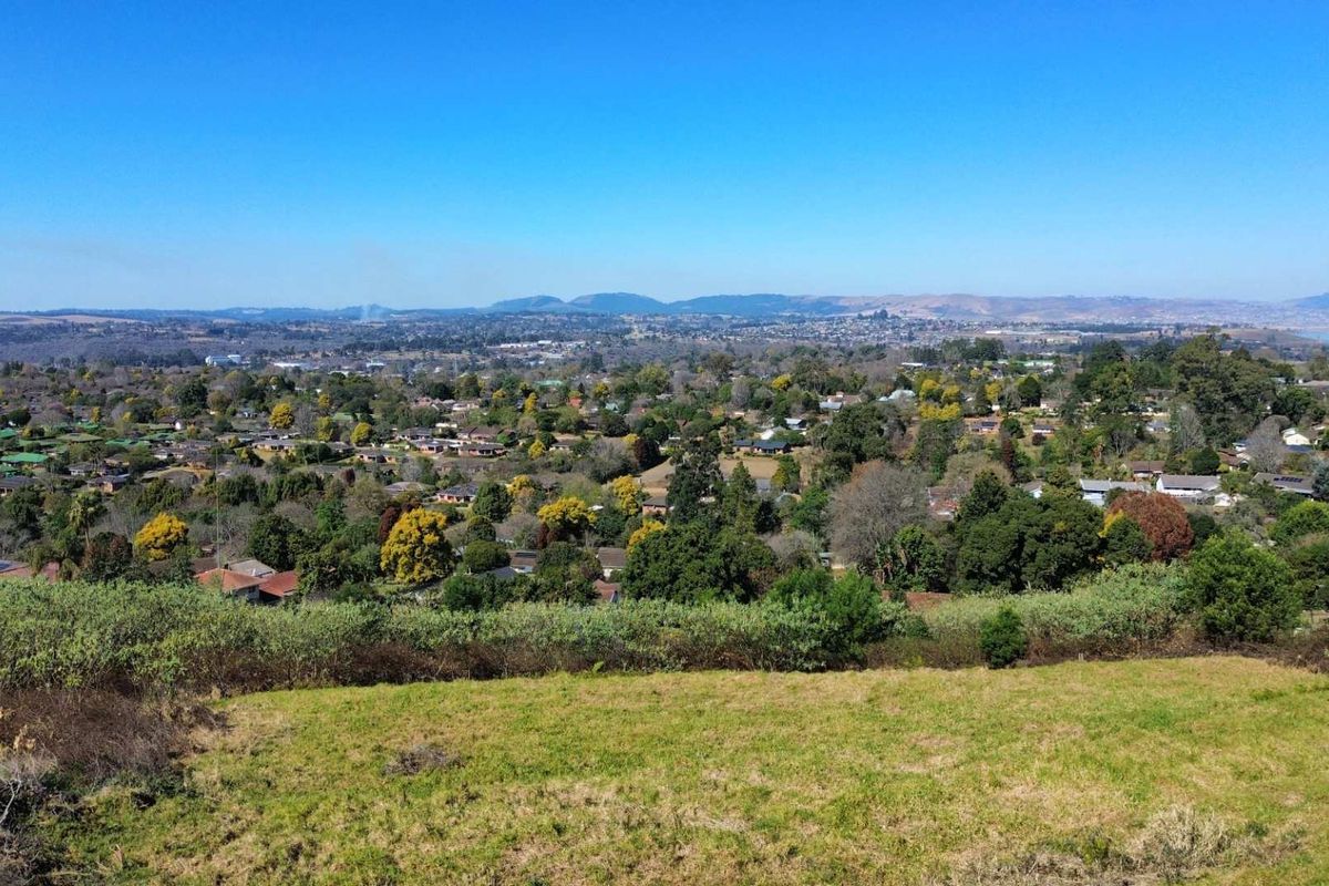 An elevated panoramic view overlooking a residential neighborhood and surrounding landscape from the vacant land plot.