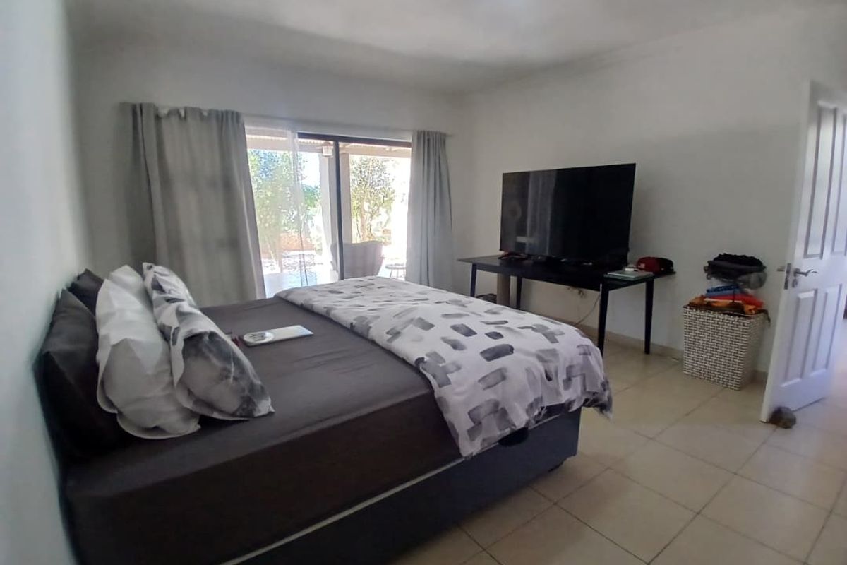 A bedroom featuring tiled flooring and a sliding glass door providing access to the outdoor area.