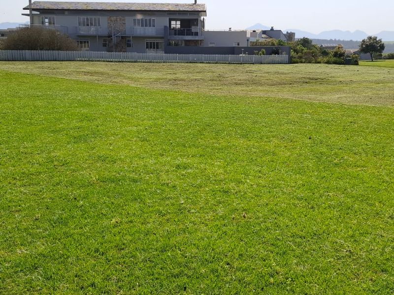 A spacious, well-maintained residential lawn area with perimeter fencing and surrounding landscape views.