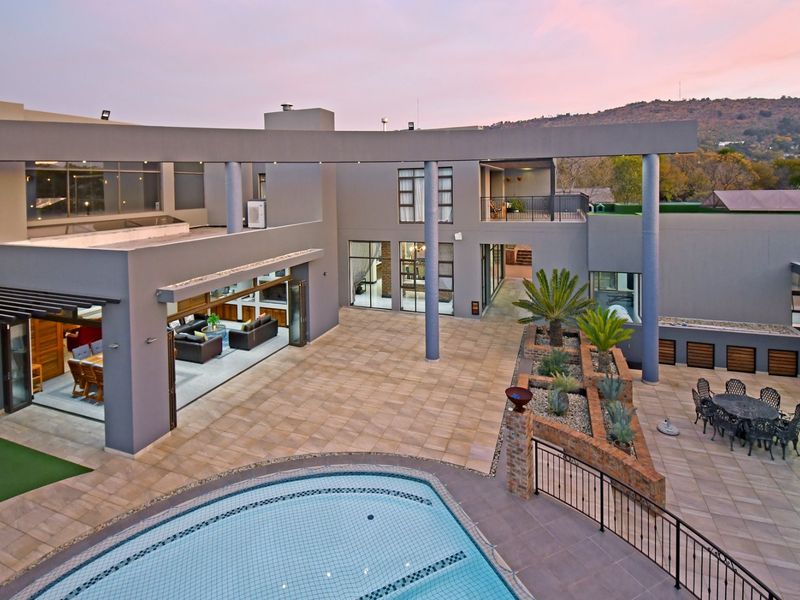Spacious rear courtyard featuring a swimming pool, expansive tiled patio, and modern architectural design with seamless indoor-outdoor flow.