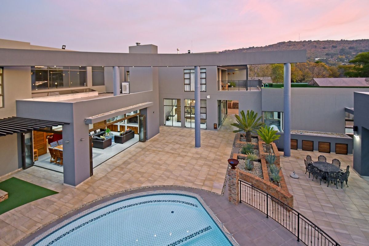 Spacious rear courtyard featuring a swimming pool, expansive tiled patio, and modern architectural design with seamless indoor-outdoor flow.