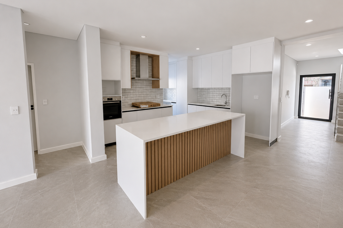 Modern open-plan kitchen featuring a central island with timber-slat detailing, white cabinetry, subway tile backsplash, and integrated oven and extractor fan.