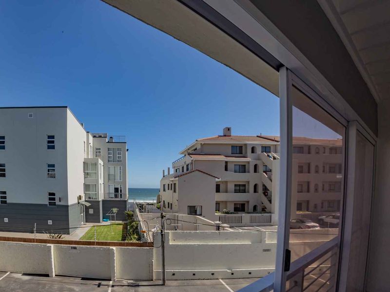 A view from an elevated position looking out over the surrounding apartment complex towards the ocean.