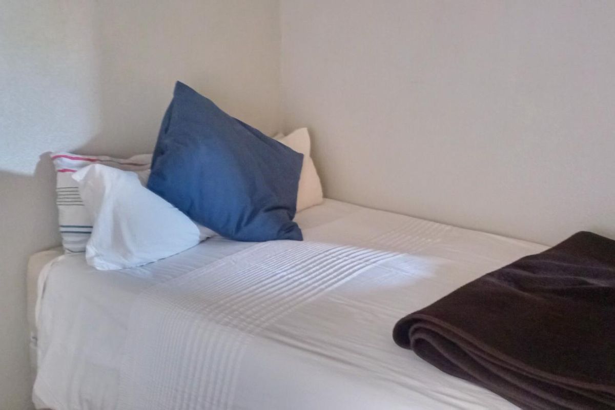 A simple bedroom space featuring neutral wall finishes and a standard electrical outlet.