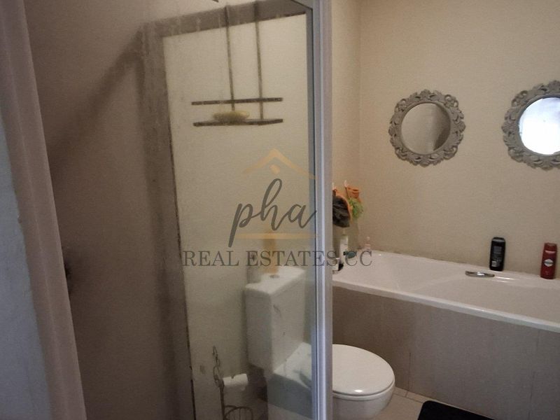 A functional bathroom featuring a shower enclosure, bathtub, toilet, and a vanity basin with modern fixtures.