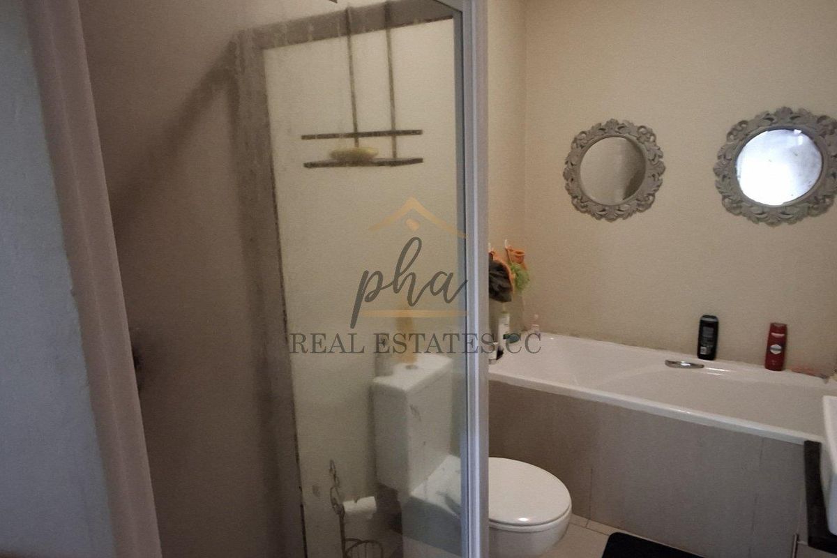 A functional bathroom featuring a shower enclosure, bathtub, toilet, and a vanity basin with modern fixtures.
