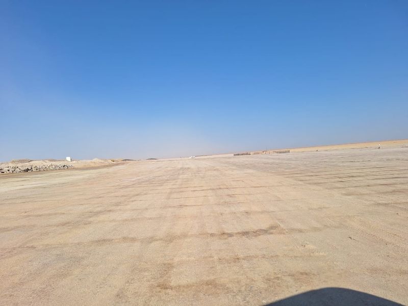 A wide, open, and cleared industrial land plot with a flat, graded surface, suitable for development or storage purposes.