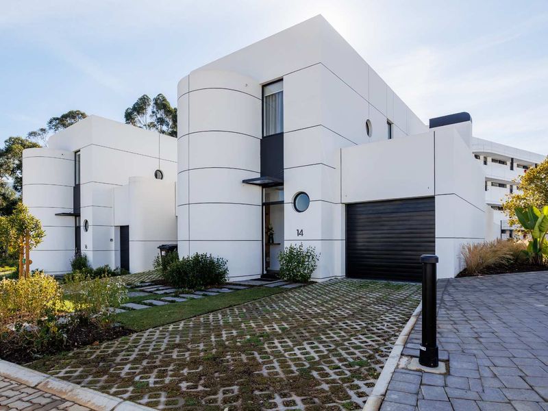 Modern architectural front elevation featuring a sleek white facade, integrated garage, and landscaped driveway entrance.
