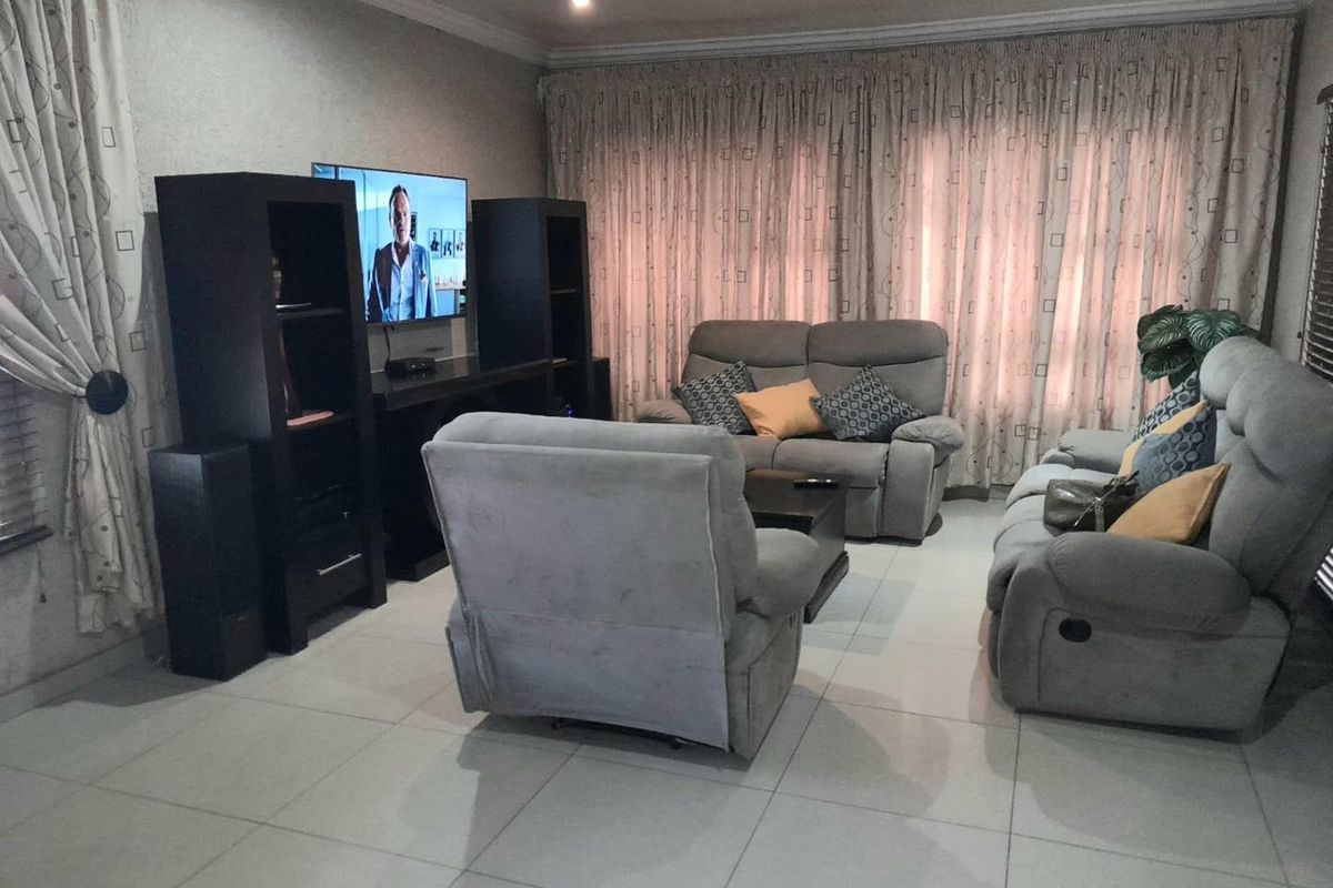 A comfortable living room featuring tiled flooring, recessed ceiling lighting, and neutral wall finishes, creating a functional and inviting space for relaxation.