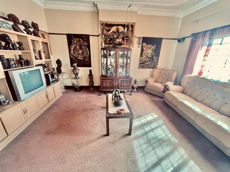 A traditional living room featuring built-in cabinetry, ornate ceiling cornicing, and a picture rail, offering a classic foundation for modern updates.