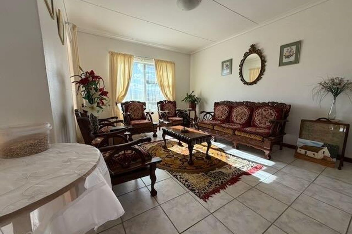 A bright living room featuring ceramic floor tiles and large windows, providing a comfortable and functional space for relaxation.