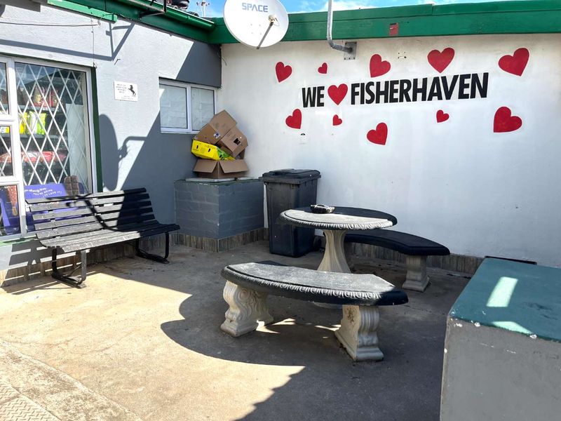 Outdoor patio area featuring concrete flooring and a painted feature wall, suitable for a casual seating space.