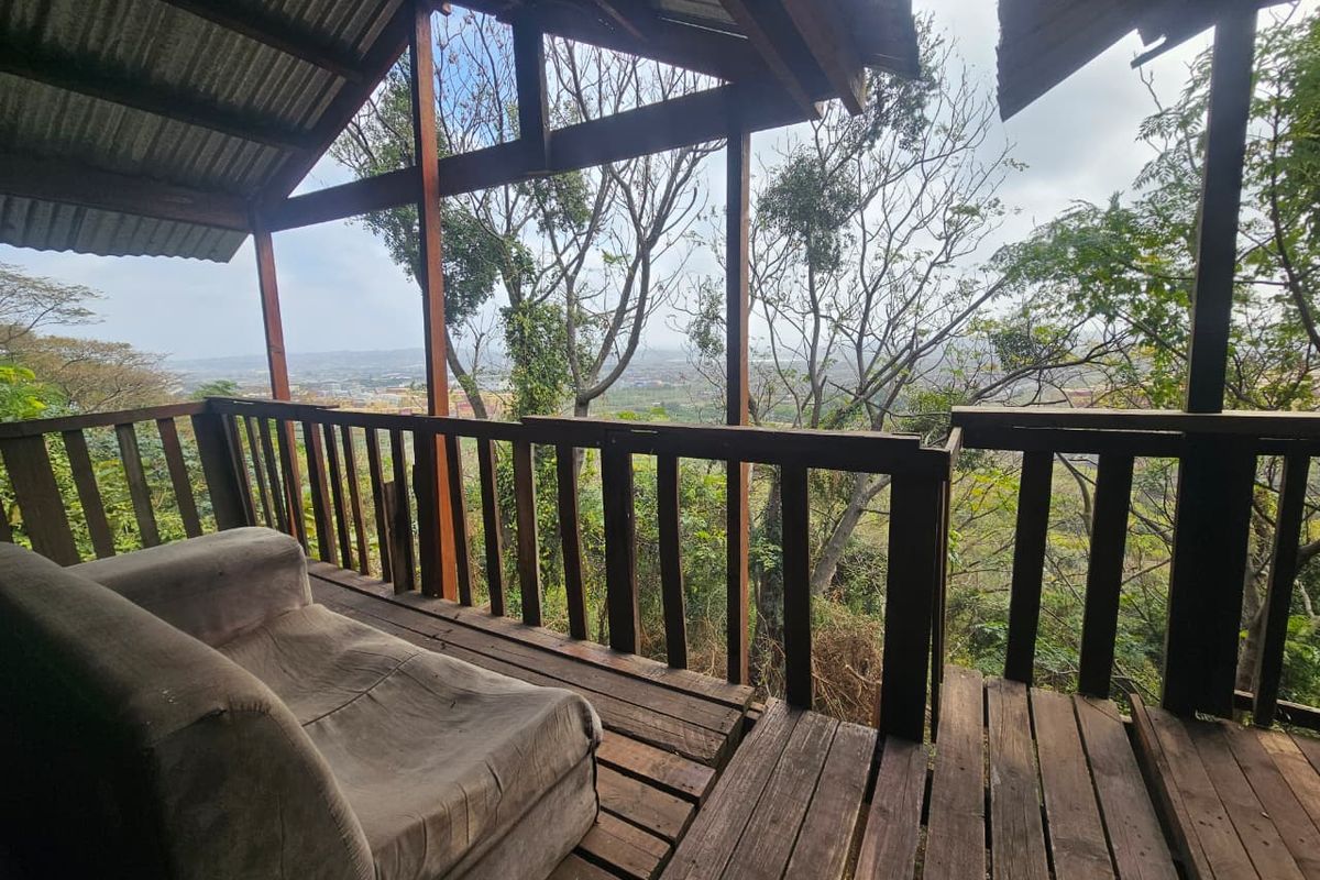 An elevated timber balcony featuring a rustic design with exposed rafters and panoramic views, requiring maintenance to the wooden decking and structural elements.