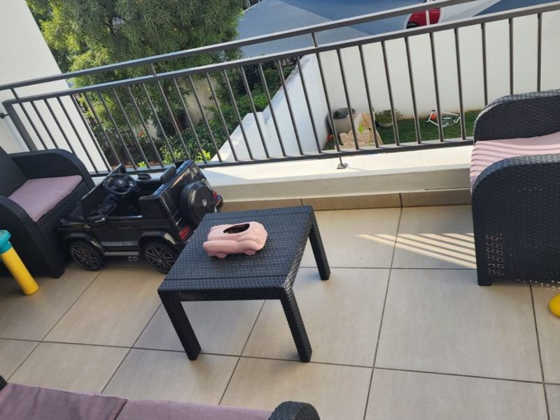 A private balcony featuring tiled flooring and a secure metal balustrade, offering an outdoor space for relaxation.