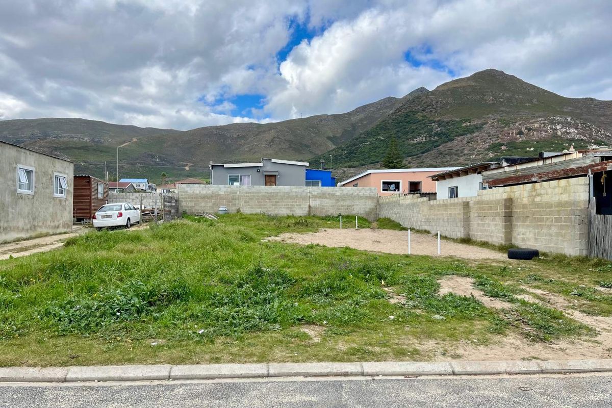 A vacant residential plot featuring perimeter boundary walls and mountain views, offering a blank canvas for future development.